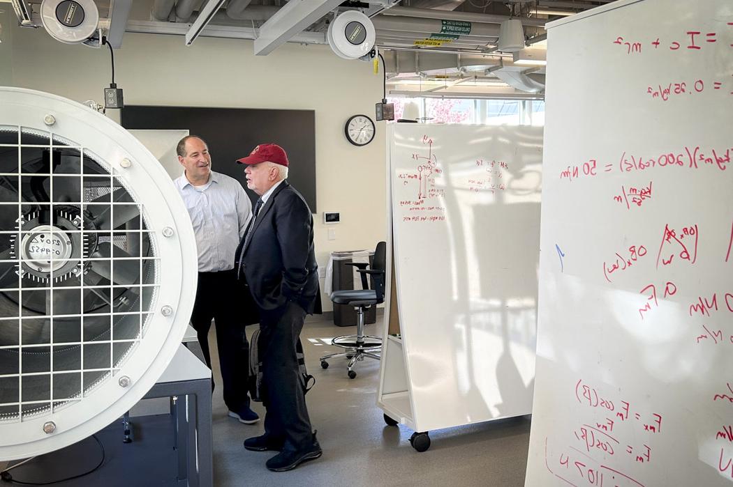 John Kozarich and Glenn Gaudette discussing a piece of lab equipment